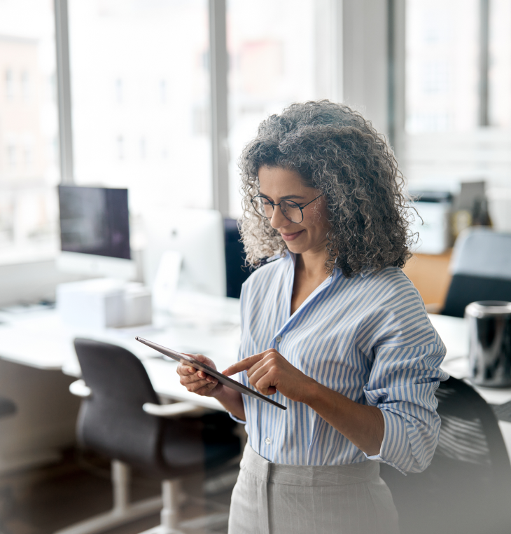 Contact Us: Woman using a tablet in an office environment